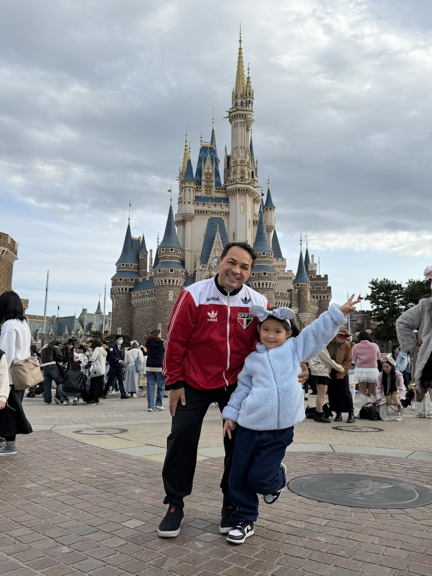 Jura, de agasalho do São Paulo FC, com a filha em um parque no Japão