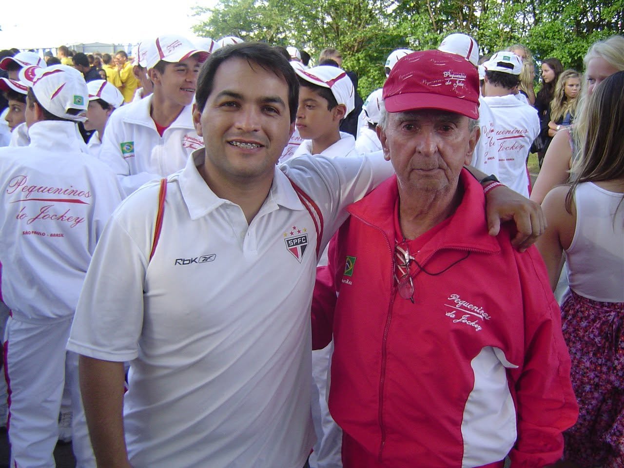 Jura com a camisa do São Paulo FC em um torneio de base, ao lado de um dirigente